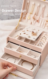 Macro detail of a three-layer drawer jewelry box with rings and necklaces organized