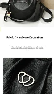 Detail of black lychee grain PU leather bag featuring interlocking heart metal hardware
