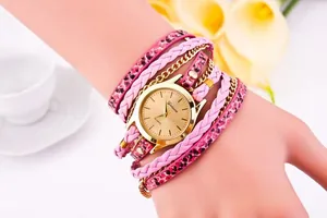 Close-up of leopard print wrap bracelet watch with gold dial and pink braided strap