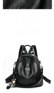 Detail of black pebbled faux leather backpack with heart logo and cartoon ox charm