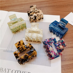 Set of six colorful leopard print acetate hair claws shown on a magazine background