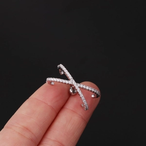 Close-up of a silver crisscross ear cuff featuring sparkling cubic zirconia stones