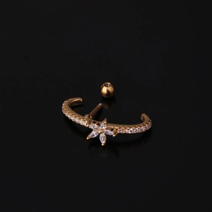 Macro detail of gold flower ear piercing with sparkling zircon stones and curved bars