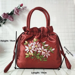 Red embroidered drawstring bucket bag with floral detail and size measurements