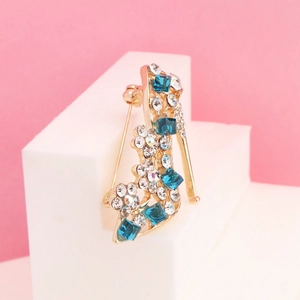 Sparkling high heel brooch with blue crystals on gold metal base and pin back detail