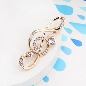 Macro detail of music note brooch with golden metal base and sparkling rhinestones