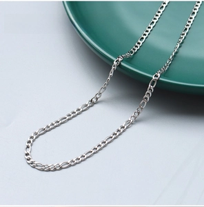 Detailed close-up of a 3mm steel color Figaro chain necklace made of stainless steel