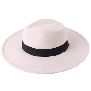 Detailed view of cream wide-brimmed felt fedora hat featuring a black ribbon band