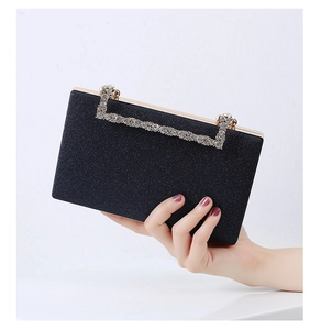 Detailed view of deep blue glitter evening clutch with gold metal frame and rhinestones