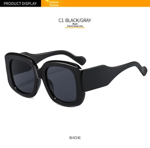 Side view of oversized black square sunglasses with thick wavy temples and gray lenses