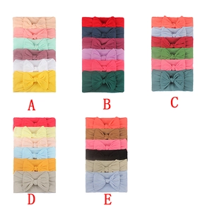 Flat lay of multiple color sets featuring soft nylon bow headbands for infant girls