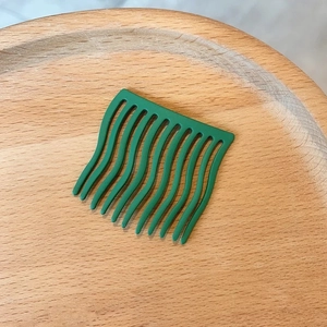 Minimalistischer grüner Haarkamm mit 11 Zähnen und Matt-Effekt auf Holztablett