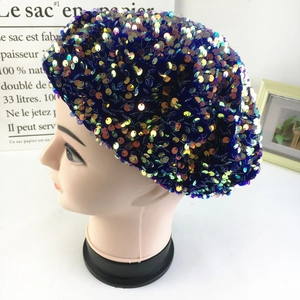 Macro detail of navy blue beret featuring vibrant iridescent laser sequins on fabric