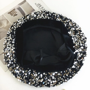 Detailed top view of black velvet beret with shiny silver sequins and soft lining