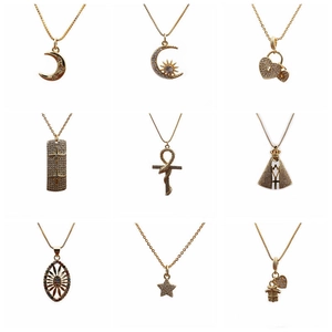 Collection of gold heart, cross, and star pendant necklaces with crystals on white background