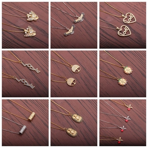 Collection of gold and silver plated heart and eagle pendant necklaces on wood texture