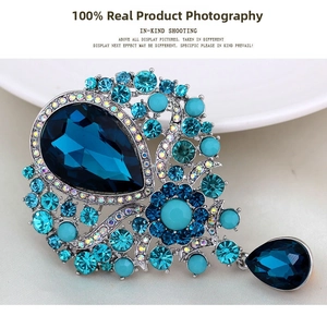 Detailed view of vintage blue crystal brooch with teardrop pendant and silver alloy frame