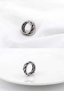 Détail rapproché montrant la texture torsadée oxydée vintage de la bague en acier titane