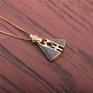 Golden necklace with blue crystal Virgin Mary pendant on dark wood texture background