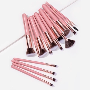 Detailed overhead view of 15 professional makeup brushes with pink handles and rose gold ferrules