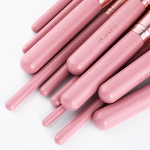 Detail of dusty pink makeup brush handles with rose gold ferrules and logo