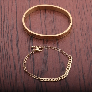Detail view of gold bangle with Roman numerals and matching chain bracelet set