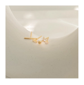 Detailed view of five-piece gold stud earring set with zircons on minimalist white decor
