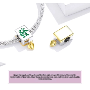 Macro shot of 925 silver Mahjong bead charm with green character and golden heart