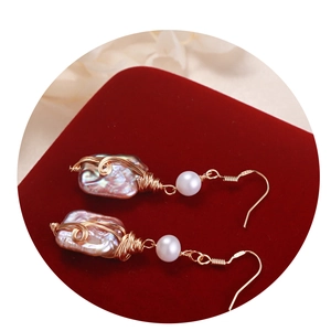 Handcrafted baroque pearl drop earrings with gold wire wrapping on red velvet