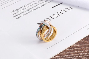 Detailed view of three-tone interlocking ring set with Roman numerals on a stylish background