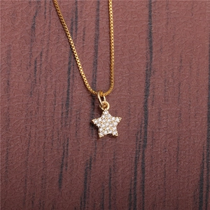 Close-up of golden star pendant necklace with sparkling crystals on leather background