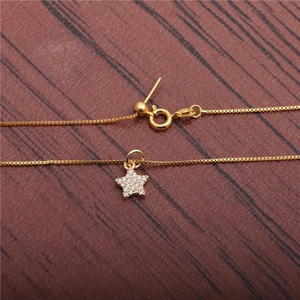 Detailed view of gold star pendant with micro-paved zircons and adjustable slider clasp