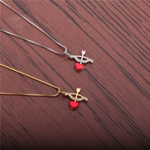Gold and silver heart necklaces with zircon bow and arrow on a wooden background