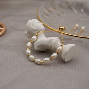 Minimalist freshwater pearl and gold bead adjustable bracelet on a white bust sculpture