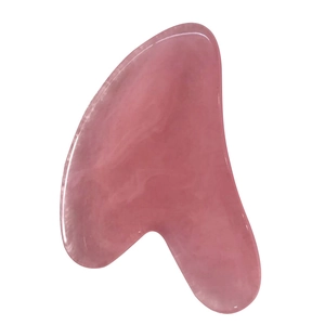 Pink heart-shaped resin gua sha tool for full body massage on white background
