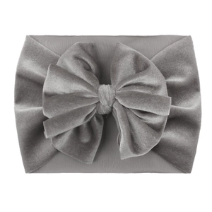 Detail shot of a grey velvet baby headband featuring a soft nylon large bow decoration