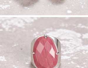 Macro shot of large faceted red gemstone ring with vintage silver wide band setting