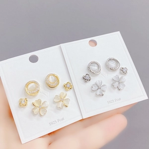Close-up of S925 silver stud earring set featuring clover and flower designs