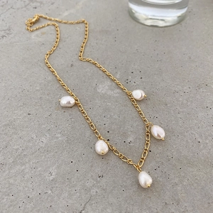 Baroque pearl necklace with 925 silver gold chain on a minimalist textured gray background