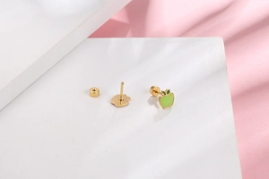 Detailed macro view of green apple screw back earring in polished gold-plated finish