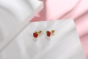 Close-up of red apple stud earrings with gold metal base and green leaf detail