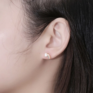 Minimalist rainbow cloud stud earring in gold-plated stainless steel worn by a model