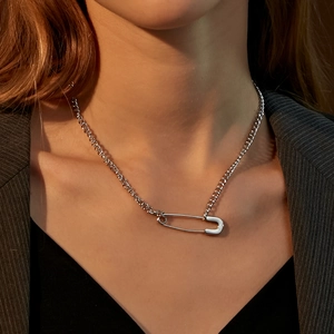 Close-up of minimalist silver paperclip pendant necklace worn by a fashion model
