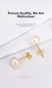 Detailed view of elegant white freshwater pearl earrings with golden butterfly backings