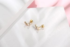 Close-up of rainbow cloud stud earrings with screw-back design on geometric pedestal