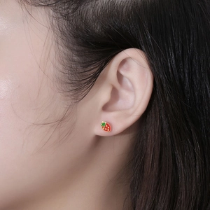 Cute red strawberry stud earrings for women with green leaves in a stylish ear-worn view