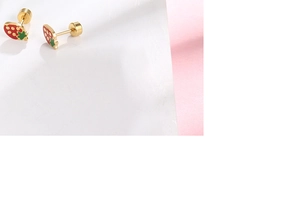 Detail of strawberry earrings with red enamel and gold-plated screw back design