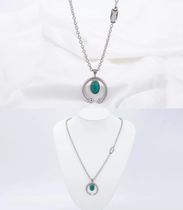 Detail of horseshoe necklace with turquoise stone and feather pendant on a white display