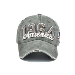 Detailed view of 1964 America embroidery and distressed holes on washed denim baseball cap