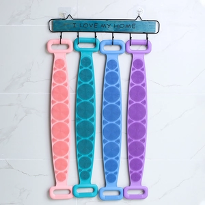 Hanging silicone back scrubber towels in pink, blue and purple on marble wall